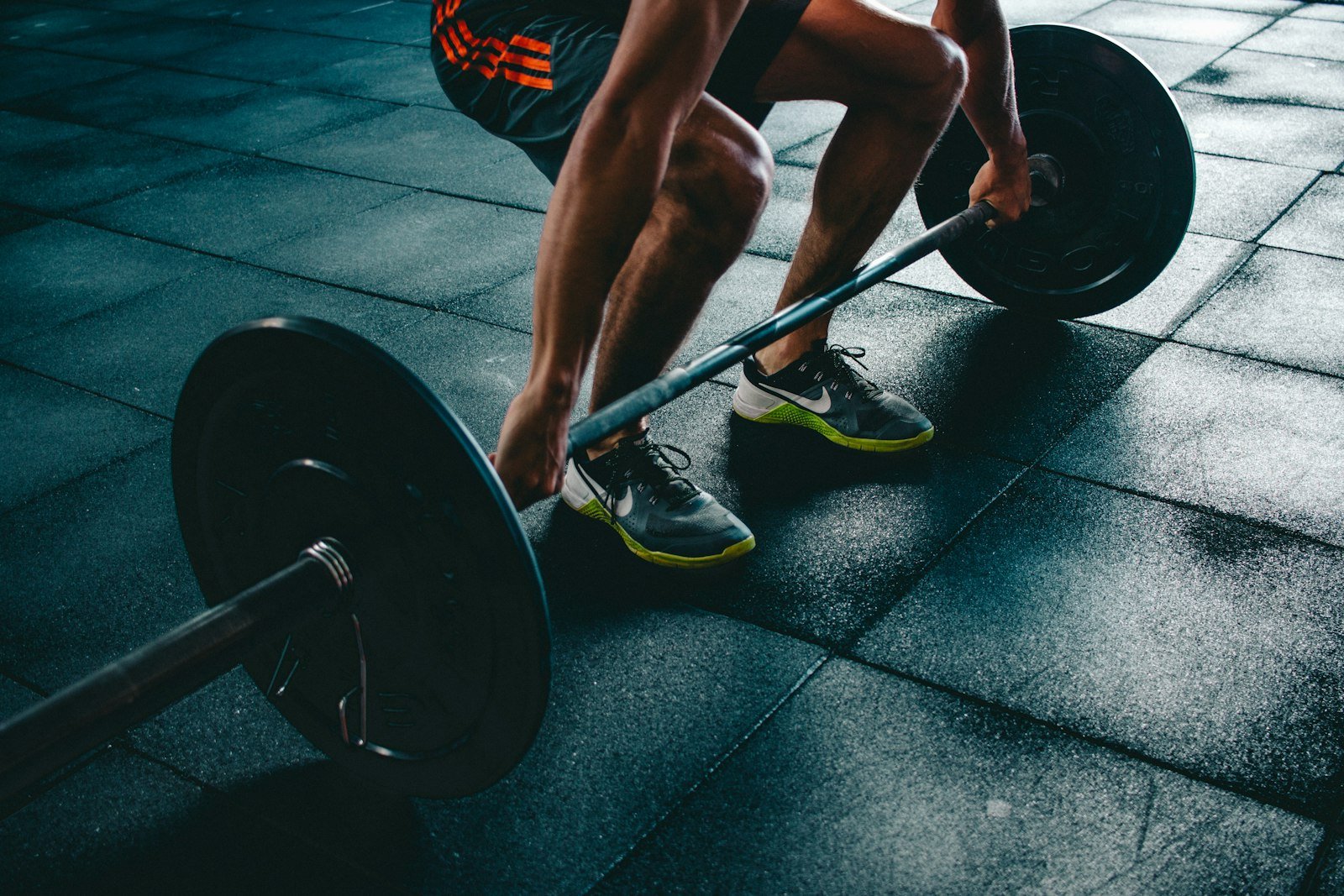 A member pulling a barbell deadlift on the Team Alpha floor